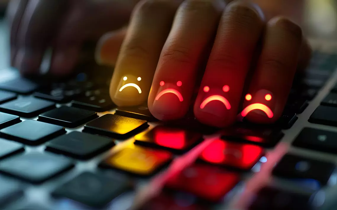 5 doigts sur un clavier avec tous au bout un visage triste dessiné dessus