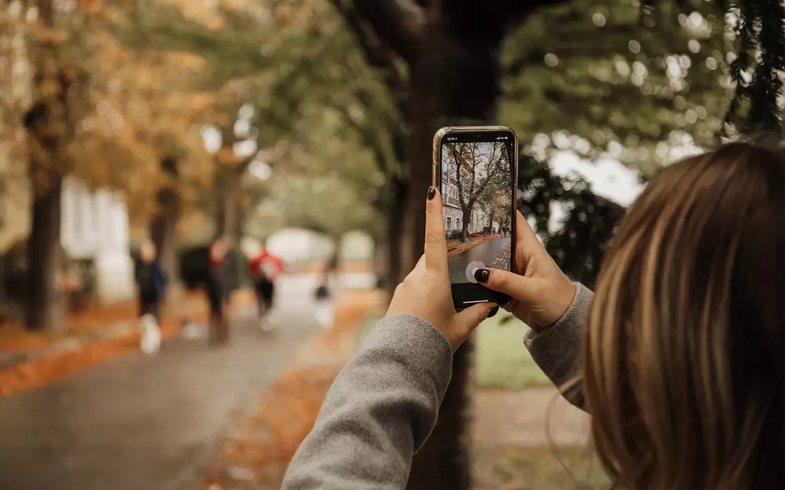 Une personne qui prend une photo dans une rue passante