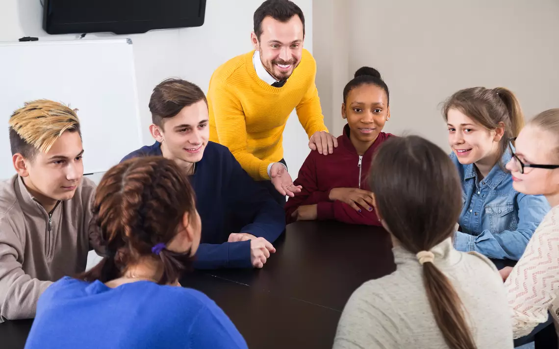 Un adulte discute avec de jeunes adolescents.